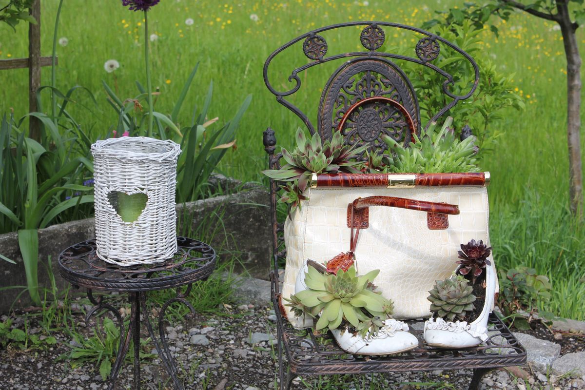 Ausrangierte Damen-Accessoires wie Schuhe und Handtasche können auch einen dekorativen Gartenschmuck ergeben - so wie hier beim Fluckinger-Hof in Wörgl.