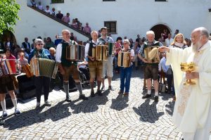 Pfarrer Matthias Oberascher segnete im Schlosshof der Wallfahrtskirche Mariastein Harmonika-Spieler und ihre Instrumente. Foto: Nageler