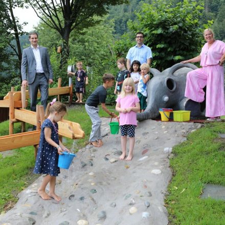 Die Kinder sind vom neuen Wasserspielplatz begeistert - hier mit Bgm. Michael Riedhart, Vbgm. Kayahan Kaya, und der Leiterin Kindergarten Grömerweg Bettina Casazza. Foto: Stadtmarketing Wörgl