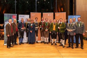 Vertreter der fünf Tiroler Musikkapellen, die in der Kategorie D am Landeswertungsspiel teilnahmen - rechts Bruckhäusls Kapellmeister Hannes Ploner und Obmann Martin Gasteiger mit der erzielten Goldmedaille. Foto: Blasmusikverband Tirol/Bernd Golas